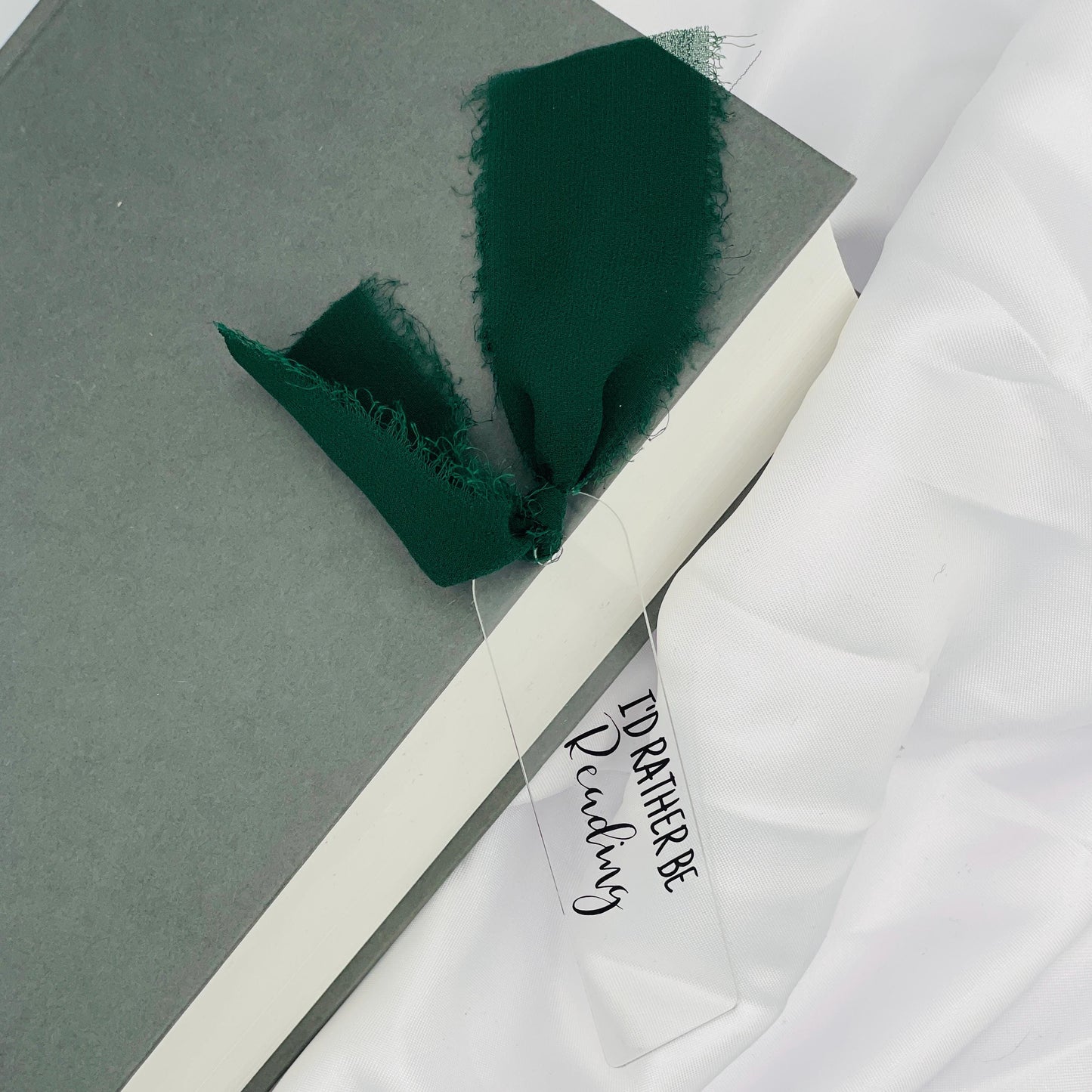 Liebevoll gestaltetes, abgerundetes Lesezeichen aus Acryl mit dunkelgrünem Chiffonband und beklebt mit schwarzem Folienaufdruck "I'd rather be Reading"