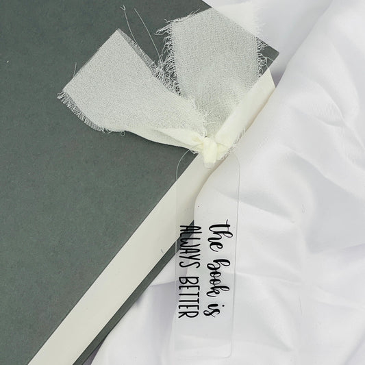 Liebevoll gestaltetes, abgerundetes Lesezeichen aus Acryl mit cremefarbenem Chiffonband und beklebt mit schwarzem Folienaufdruck "the book is always better"