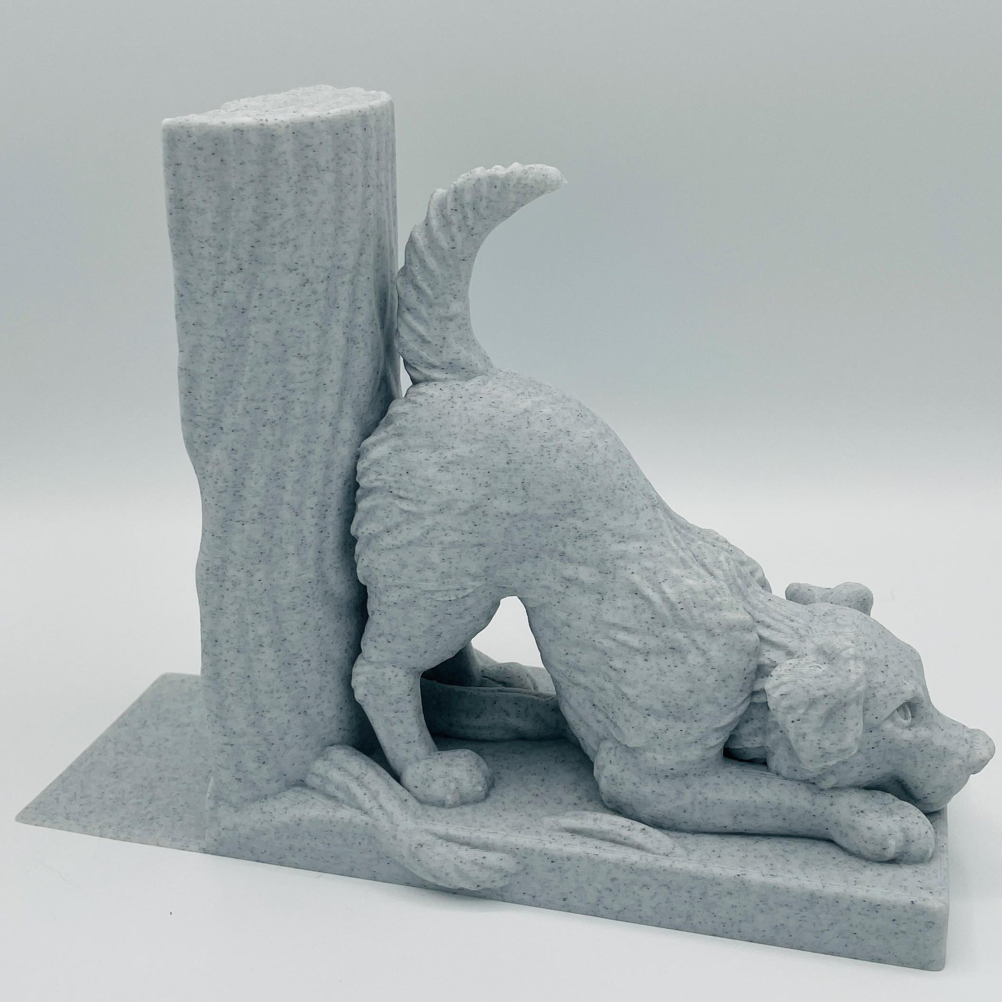 Detaillierte Ansicht einer 3D-gedruckten Buchstütze eines süßen Hundes in Seitenansicht, der mit dem Oberkörper auf dem Boden lehnt im Farbton Marmor