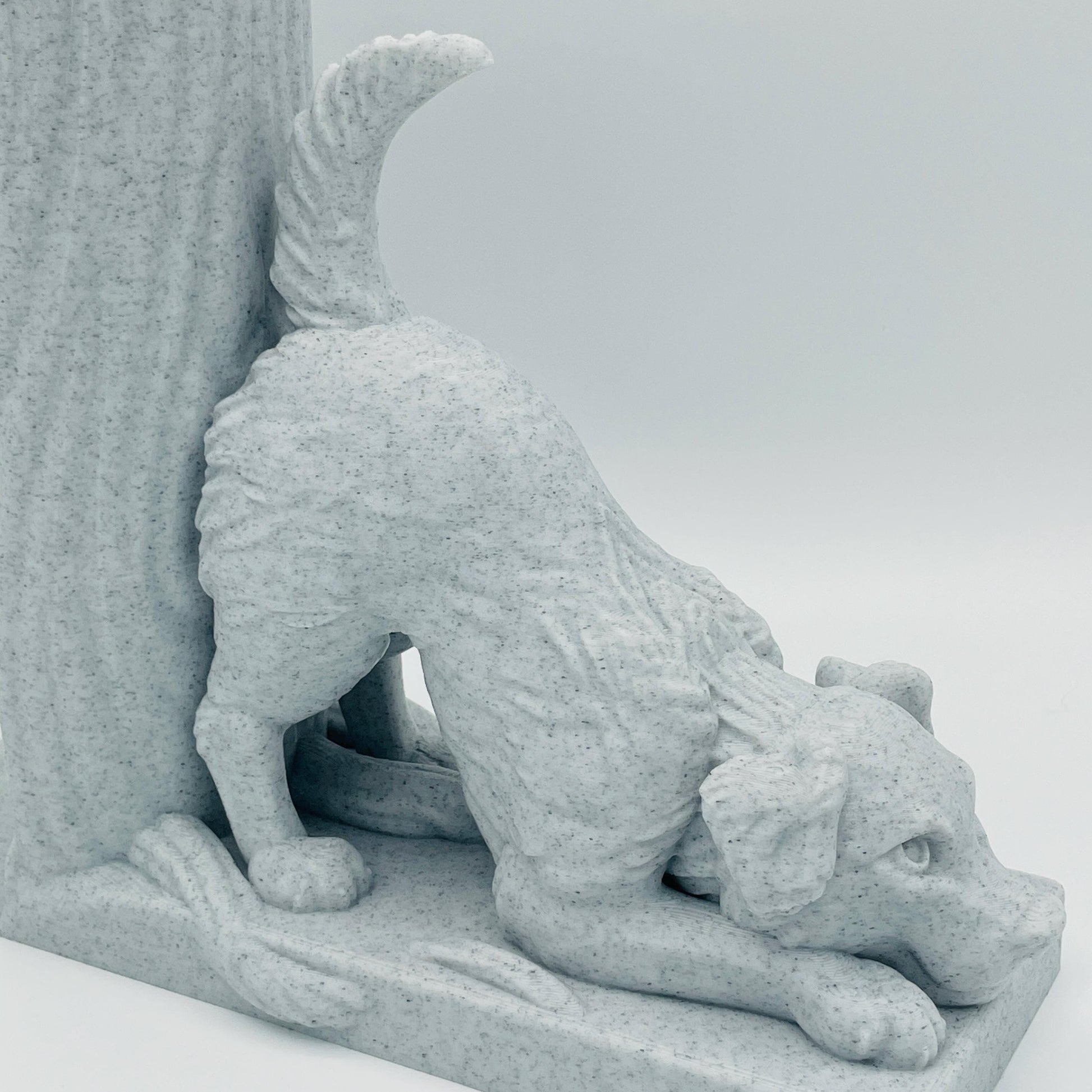 Detaillierte Ansicht einer 3D-gedruckten Buchstütze eines süßen Hundes in Seitenansicht, der mit dem Oberkörper auf dem Boden lehnt im Farbton Marmor