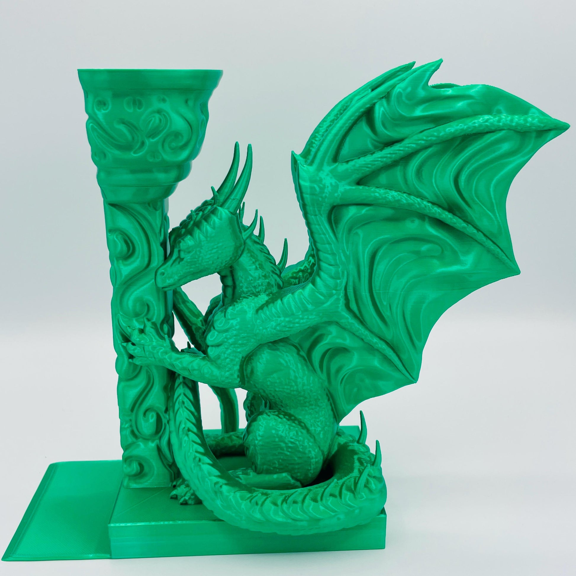 Detailliertere Ansicht einer 3D-gedruckten Buchstütze eines Drachens in Seitenansicht, angelehnt an eine Säule im Farbton Smaragd Grün
