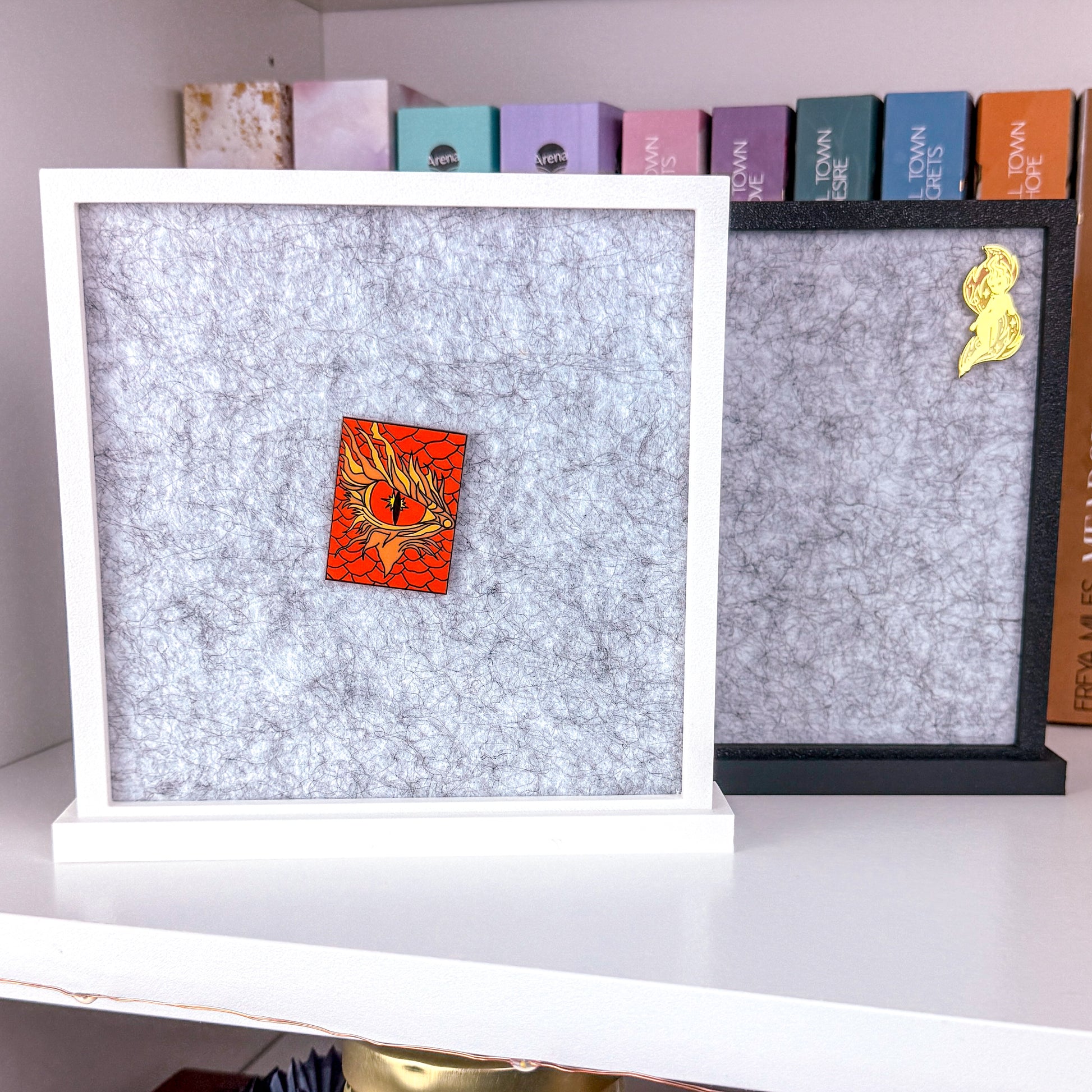 Zwei Pin Aufsteller 3D gedruckt aus PLA. Einer in Matt Weiß und der andere in Matt schwarz. Im Inneren des Rahmens befindet sich eine graue Filz Pinwand.